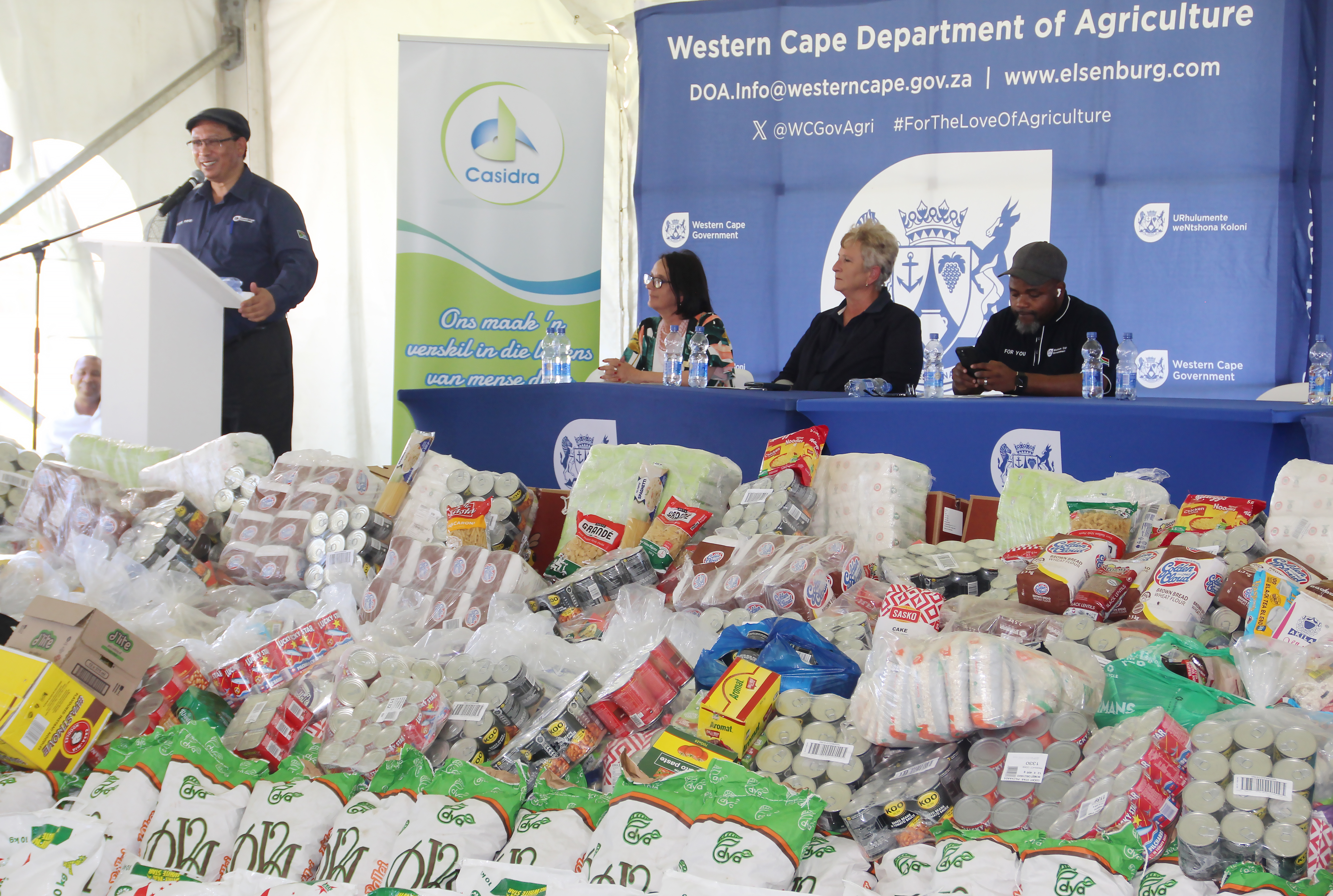Minister Meyer addressing audience at WFD with food mountain the foreground