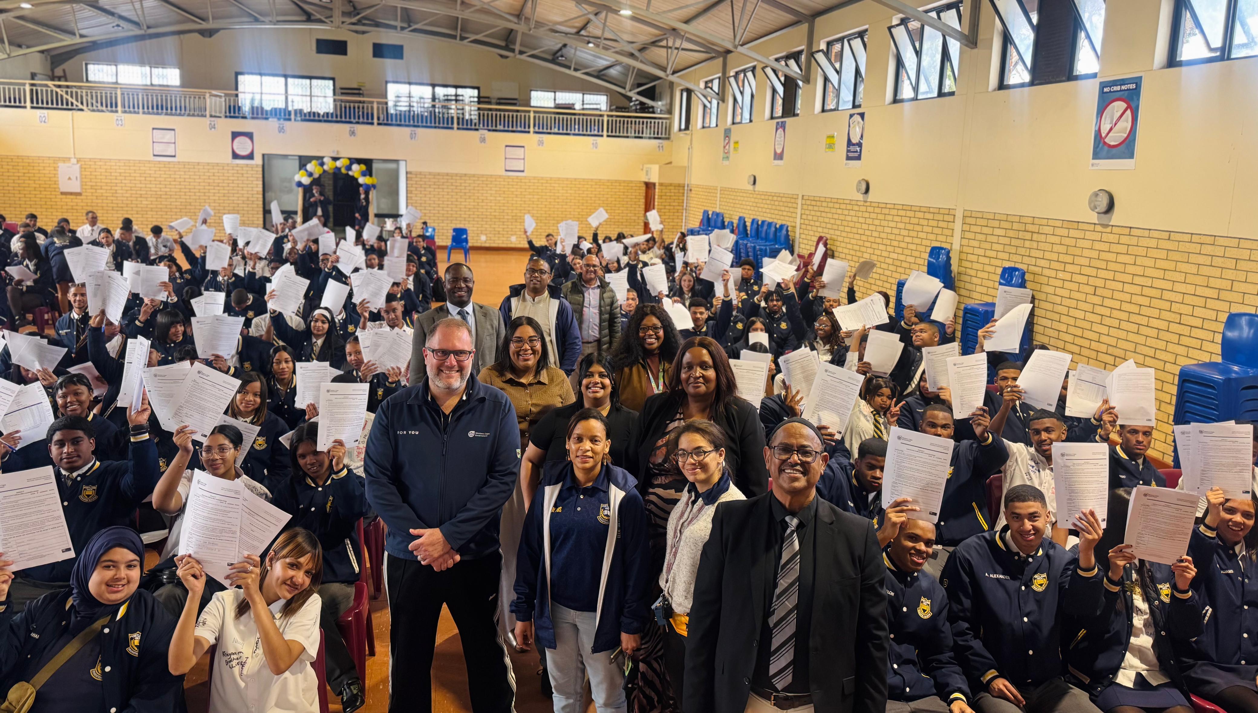 Minister Londt attends Portland High School’s pledge signing ceremony, in front is Principal Ridwaan Williams, teachers and WCED officials.