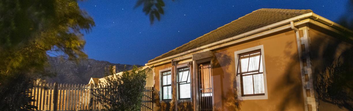 A picture of a house taken at night under a clear starry sky