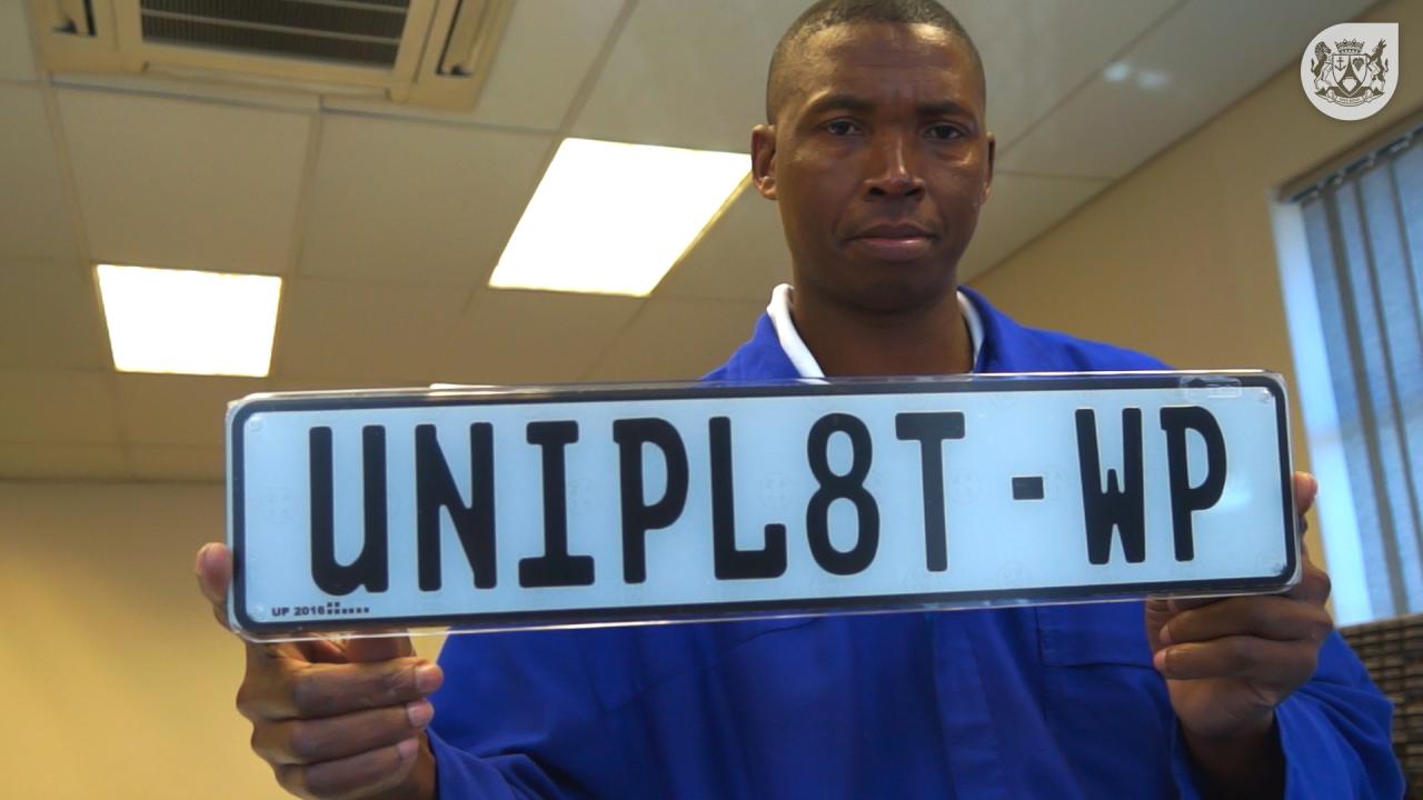 A man holding up a personalised number plate