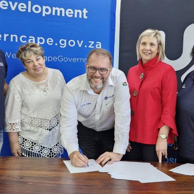 Signing of agreement: Bronwynn Weilbach (Occupational therapist at Outeniekwa CYCC), Chief Director Leana Goosen, Minister Jaco Londt, Elsie Harmse (Africa Skills CEO), and Barbara Nicholas (Outeniekwa CYCC Manager)